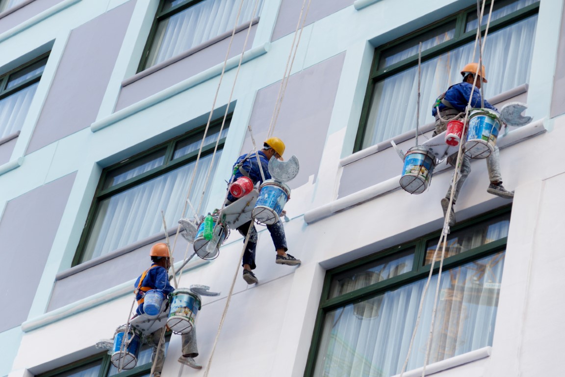 Worker are painting the color in high rise buildings.